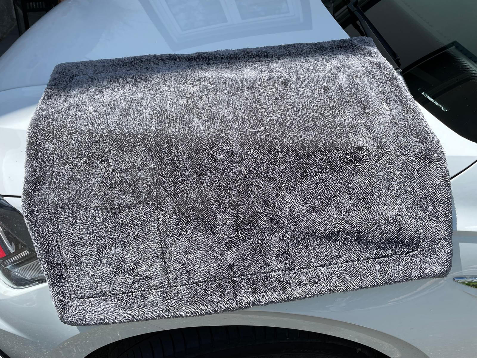 Erixen Mikrofaser Trockentuch auf einer Fahrzeugoberfläche, zeigt die saugstarke Textur für streifenfreies Trocknen.