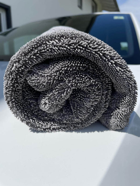 Erixen Mikrofaser Trockentuch in Grau, 1600 GSM, gerollt auf einem Auto für streifenfreies Trocknen.
